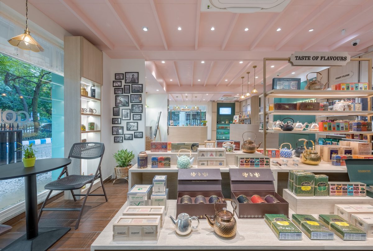 Warm-toned boutique interior with wooden flooring, tea display shelves, and reception counter designed by Internal Affairs Interiors Pvt. Ltd.