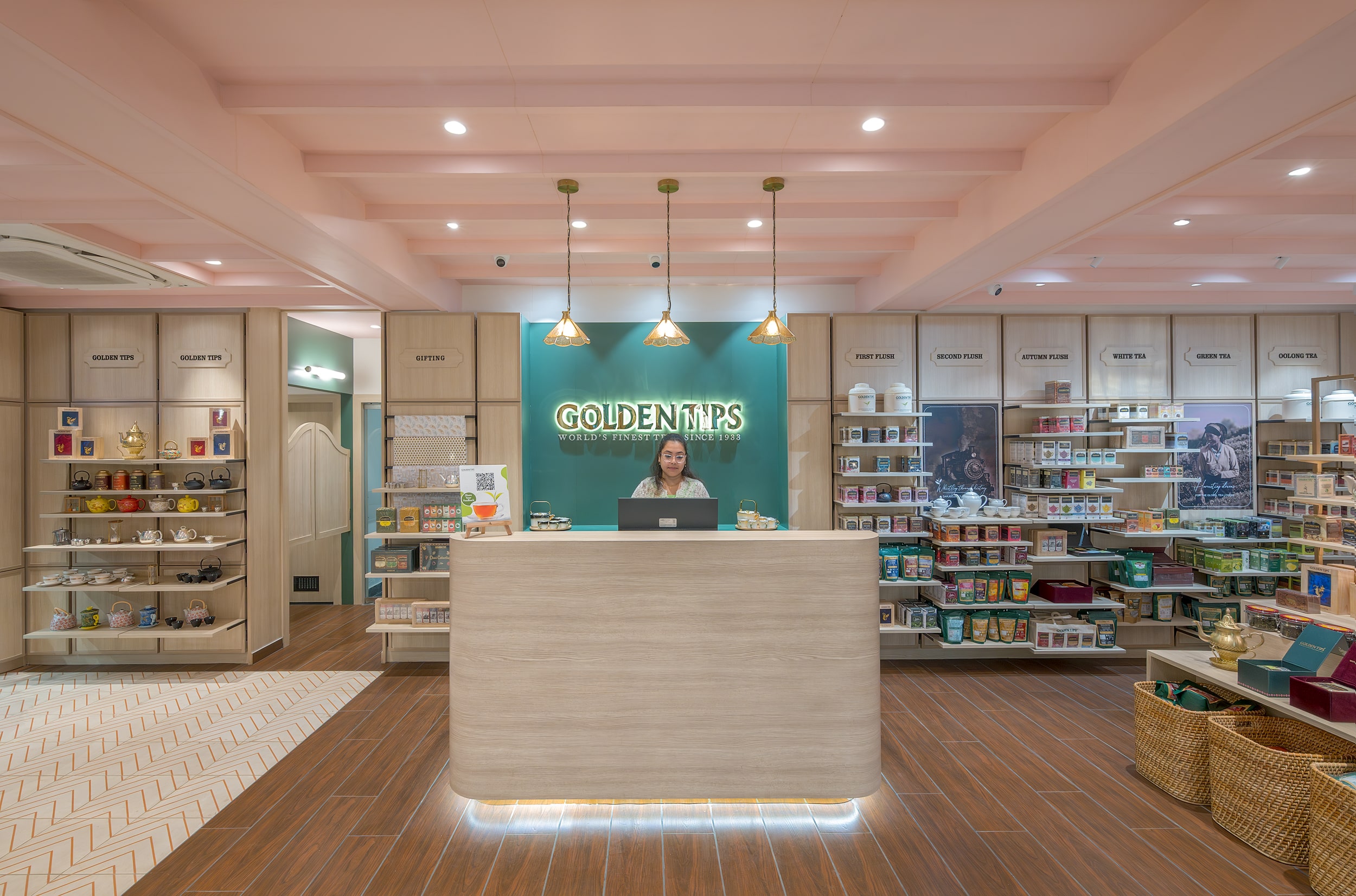 Reception area with illuminated Golden Tips logo, soft pink ceiling, and organized product display shelves inside the boutique.